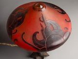a red and black vase with a horse on it