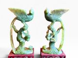 deux figurines posées sur un socle rouge