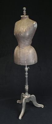 une image représentant un mannequin posé sur un pied métallique, sur fond noir