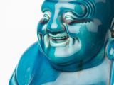a blue statue of a laughing buddha on a white background
