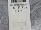 the label is attached to a gray t - shirt that has a barcode on it
