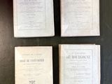 quatre vieux livres posés sur une table, sur fond noir