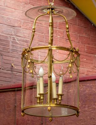 a gold chandelier hanging from a red brick wall