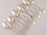 six silver spoons and a fork on a white surface