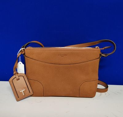 un sac à bandoulière en cuir beige orné d'une étiquette