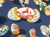 many different types of painted eggs on a blue surface