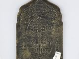 an old metal plaque with a cross on it on a white surface