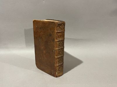 un vieux livre posé sur une table à côté d'un fond blanc