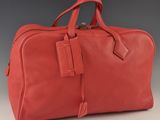 un sac de voyage en cuir rouge posé sur une table