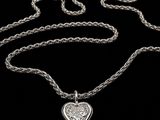 a close up of a heart shaped pendant on a chain