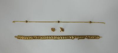 two gold bracelets and a gold necklace on a white surface
