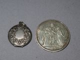 two silver coins sitting next to each other on a white surface