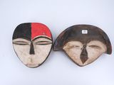paire de masques en bois représentant des visages rouges et noirs sur fond blanc