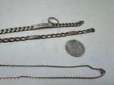 three different types of chains and a coin on a table