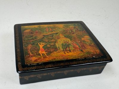 une boîte noire ornée d'une peinture, posée sur une table