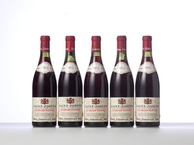 four bottles of wine are lined up on a table