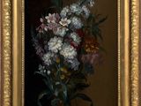 painting of a bouquet of flowers in a gold frame on a brown background