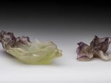 deux morceaux de verre vert et violet posés sur une surface blanche