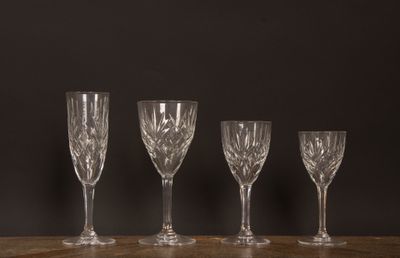 four empty wine glasses lined up on a wooden table