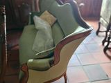 a green couch sitting in a living room next to a chair