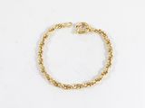 gros plan d'un bracelet en chaîne en or sur fond blanc