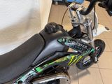 a black and green dirt bike parked in a room