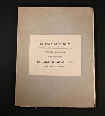 un vieux livre posé sur une table à côté d'une table noire