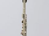 a silver flute sitting on top of a clear glass stand