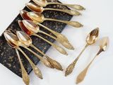 five spoons and two spoons sitting on a black plate