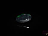 un gros plan d'un diamant vert et noir sur une surface noire