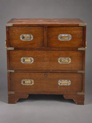 an old wooden chest of drawers with brass hardware on top