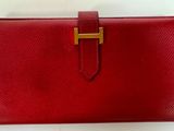 un portefeuille en cuir rouge muni d'un fermoir doré