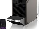 un gros plan d'une machine à café avec une tasse de café à côté