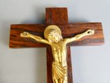 a gold crucif on a wooden cross on a wall