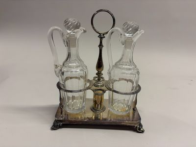 trois bouteilles en verre et un support en métal posés sur la table