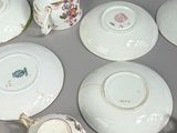 many cups and saucers sitting on a table