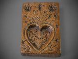 une vieille plaque en bois sur laquelle est sculpté un cœur
