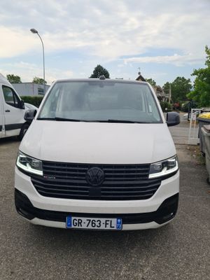 the front of a white van parked in a parking lot