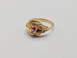 a close up of a gold ring with a pink stone