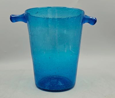 a blue glass vase with handles sitting on a table