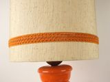 an orange table lamp with a white shade on it