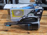 a black and blue vacuum sitting on a wooden table