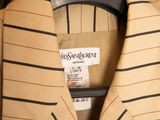 a tan jacket with black stripes on it hanging on a hanger