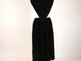 a black dress on a mannequin stand against a white background