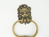 an image of a brass lion head ring on a white background