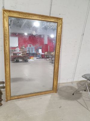 un grand miroir au milieu d'une pièce, avec une chaise à côté