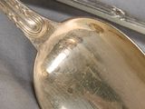 a silver spoon and a pair of tonges on a table