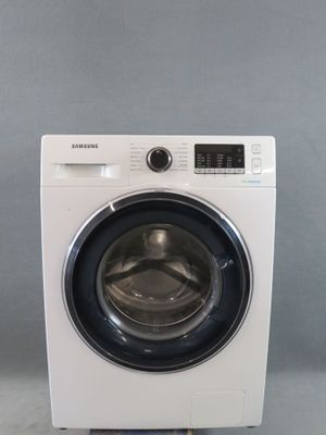 a close up of a white washing machine on a gray surface