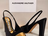 une paire de chaussures noires et dorées posées sur une table blanche