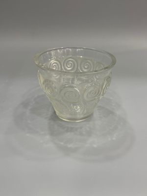 un saladier en verre décoré d'un motif, posé sur une assiette